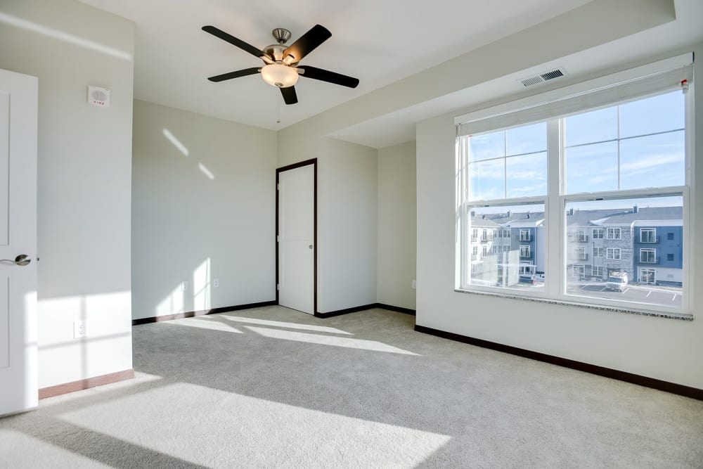 Spacious main bedroom with a large window for natural lighting at Crossroads at Elm Creek in Maple Grove, Minnesota