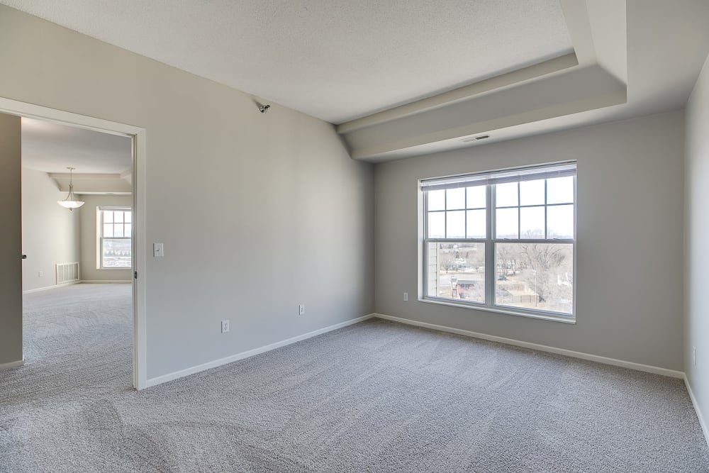 Spacious main bedroom with a large window for natural lighting at Provence Apartments in Burnsville, Minnesota