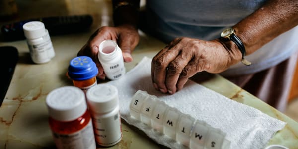 Resident sorting various assorted medications on a table at Holton Manor in Elkhorn, Wisconsin