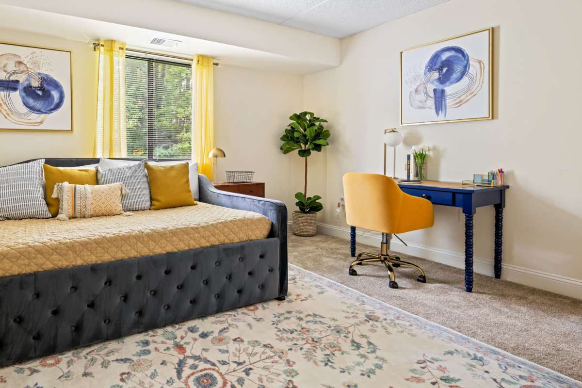 Bedroom with a large window, office table and an armchair at Windsor Court and Tower in Silver Spring, Maryland