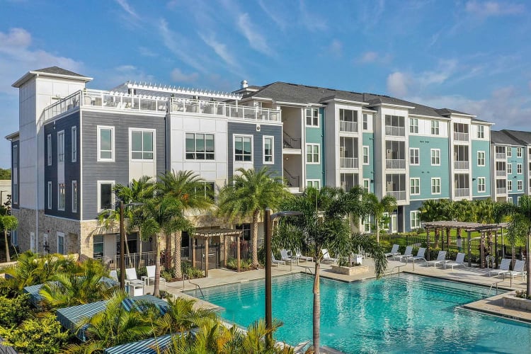 Swimming pool area surrounded by lush flora at Vue at Belleair in Clearwater, Florida