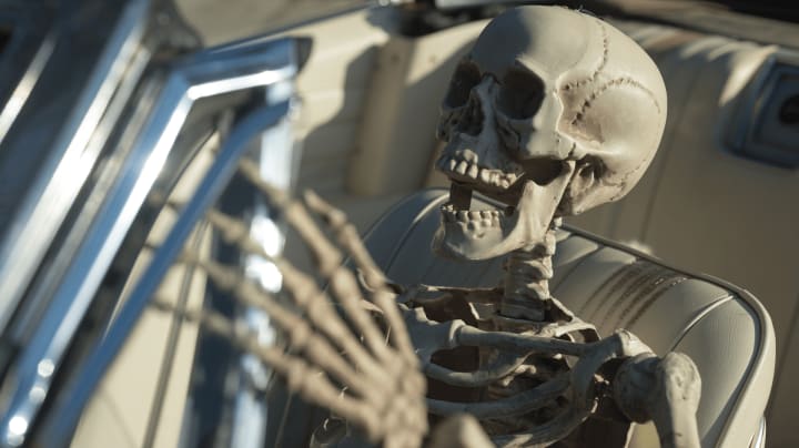 skelton in driver's seat of convertible