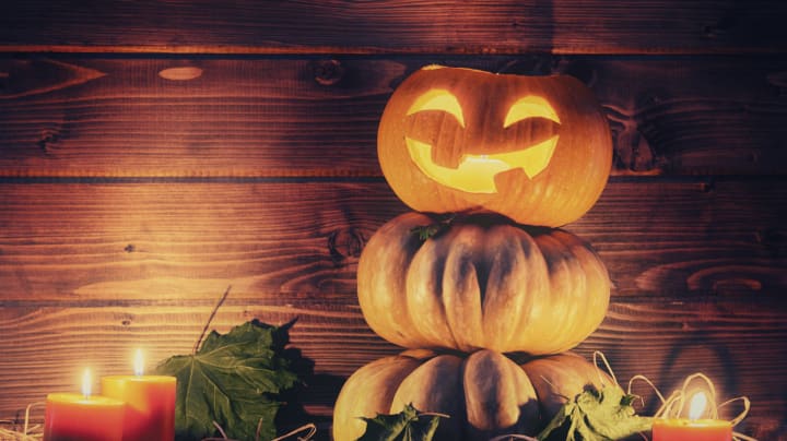Jack-o-lantern sitting on stack of gourds