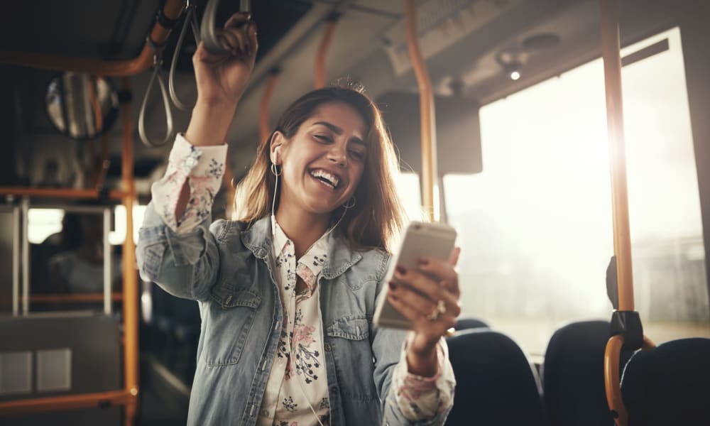 Resident laughing while reading something on her phone while riding the bus to work near Oaks Braemar in Edina, Minnesota