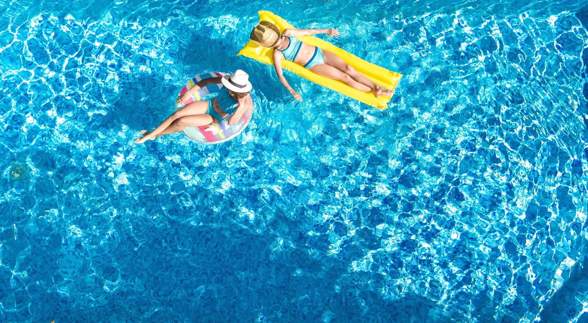 2 Residents Floating on Inflatable Pool Toys on a Bright Blue Pool at 1221 Vallejo Apartments in Novato, California