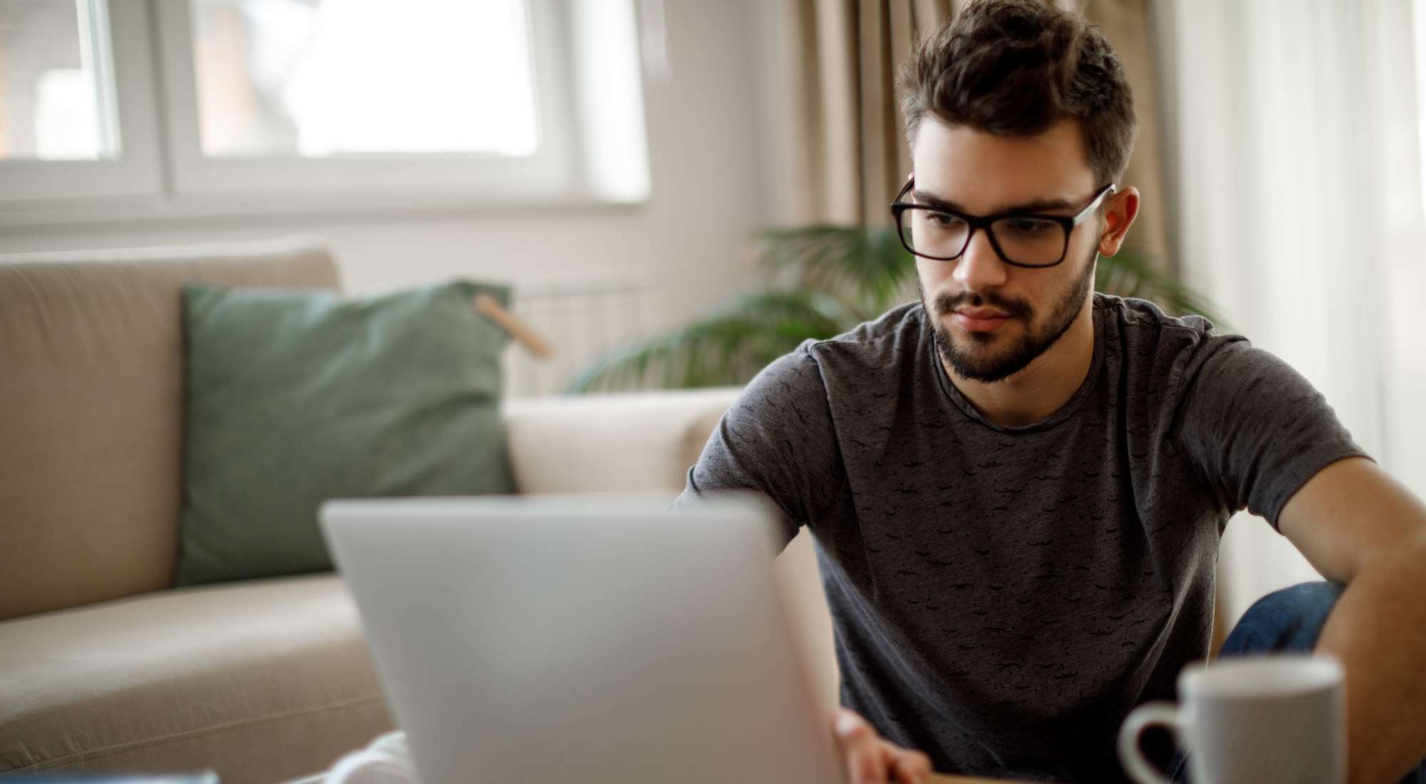 Resident with laptop sitting in living room at Riverbirch in Ames, Iowa