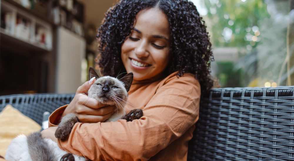 Resident cuddling her cat in their pet-friendly home at Bluffs at Evergreen in Everett, Washington