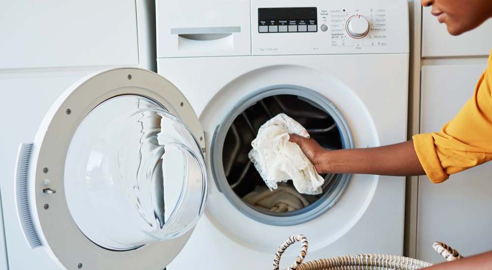 Resident putting clothes in the laundry at San Jose Gardens in San Jose, California