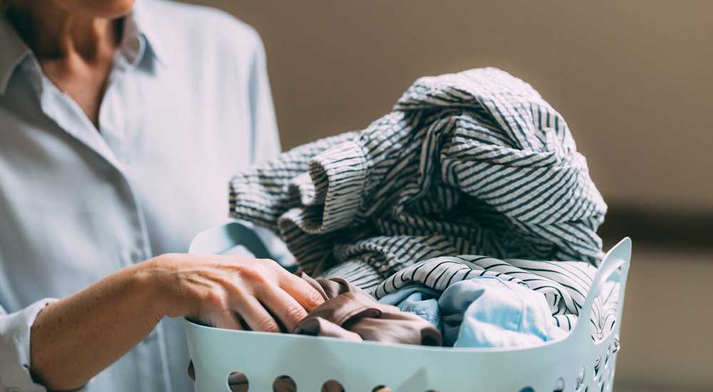Resident carrying a laundry basket at Tristan Townhomes in Garden City, Georgia