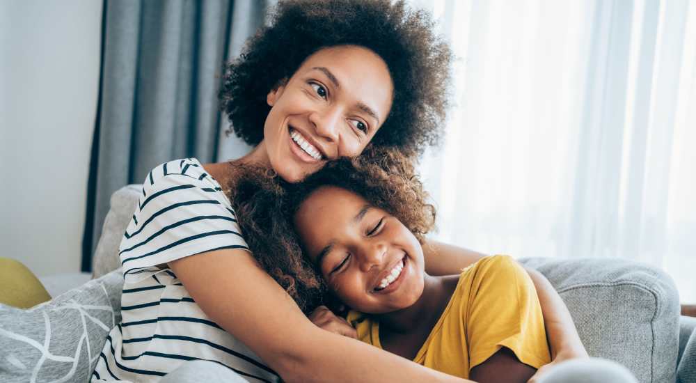 Mother and daughter relaxing in the living room at Huntington Reef in Huntington Beach, California