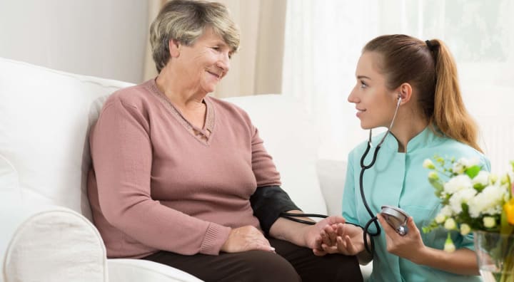 Senior getting blood pressure taken by nurse