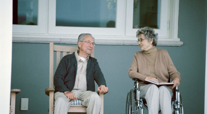 Two seniors sitting on porch chatting