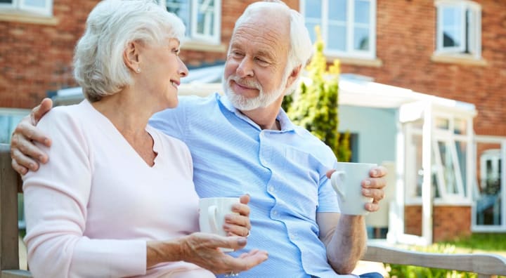 Senior couple enjoying coffee on a bench