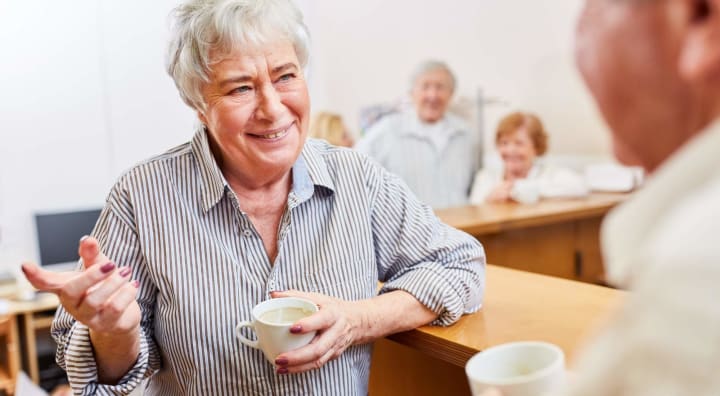 Senior woman with coffee chatting to someone off camera