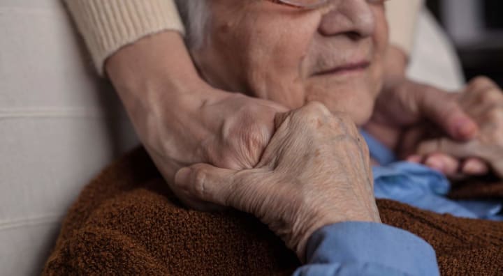 Senior man holding hands of someone off-camera