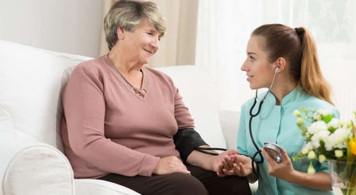 Senior woman getting blood pressure checked by nurse