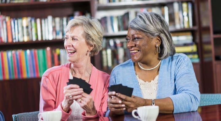 Senior women laughing and playing cards