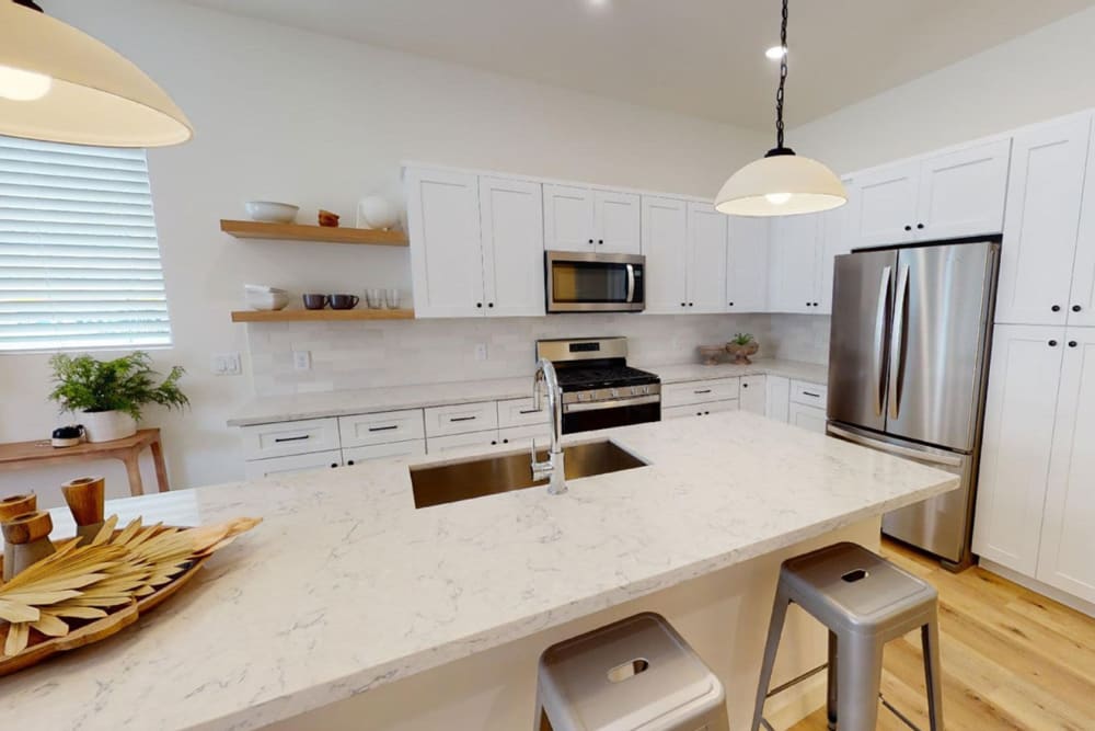 Gourmet kitchen with granite countertops in a model home at Novella at Biltmore in Phoenix, Arizona