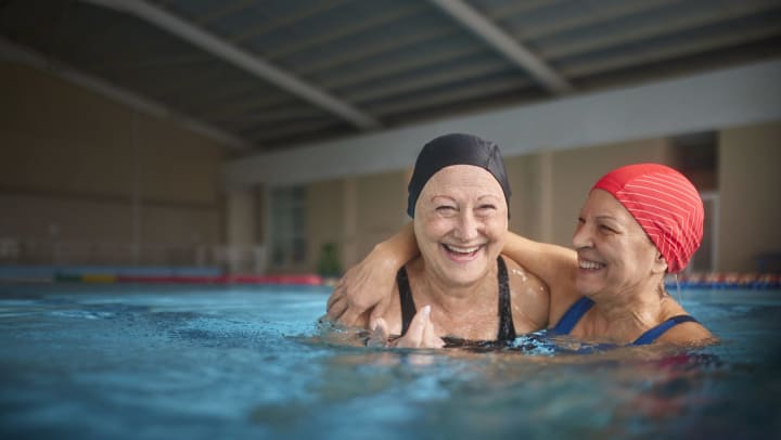 Two people smiling in an indoor pool.