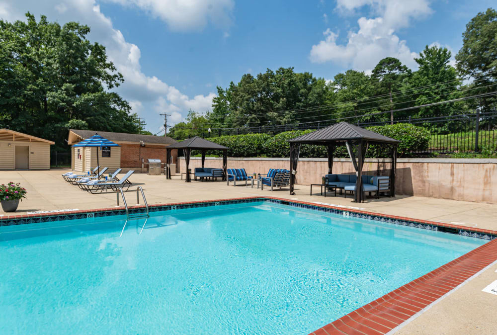 Swimming pool with lounge chairs and cabanas at Parke Laurel Apartment Homes