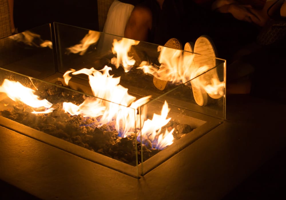 Feet by the fire pit in the evening at the rooftop lounge at Verano in Perris, California 