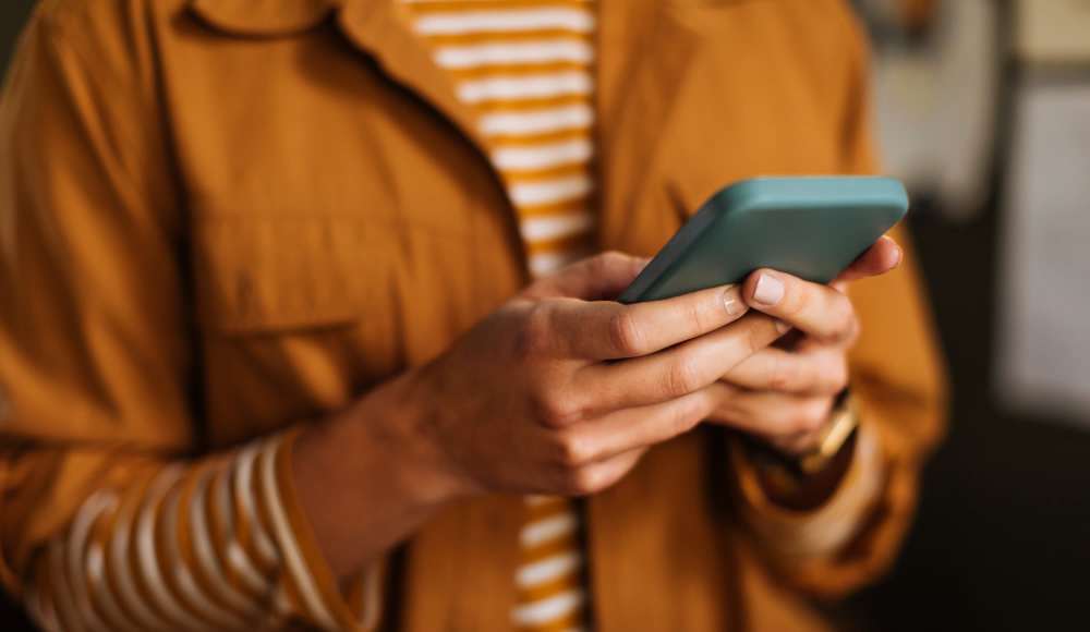 A woman using her phone at Pelican Isles Apartments in Sebastian, Florida