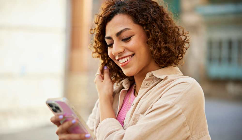 Resident woman using her phone at Dakota San Antonio in San Antonio, Texas