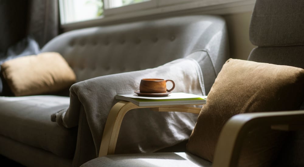 Leather couch and a comfortable chair in a model home's living space at Sharp Leadenhall Apartments in Baltimore, Maryland