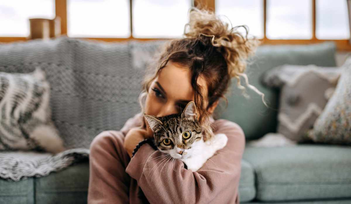 Woman sitting on a couch holding a cat in her arms at Attain Shockoe, Richmond, Virginia