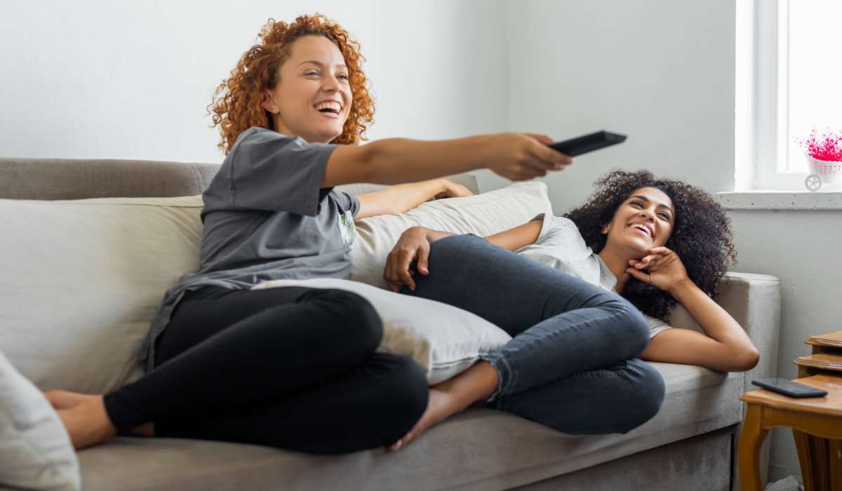 Residents relaxing on the couch and watching TV in their new luxury home at Shannon Park in Goose Creek, South Carolina