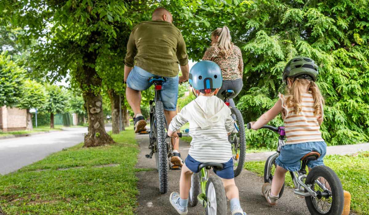 Family biking together on a tree-lined path near Fishtown Flats in Philadelphia, Pennsylvania