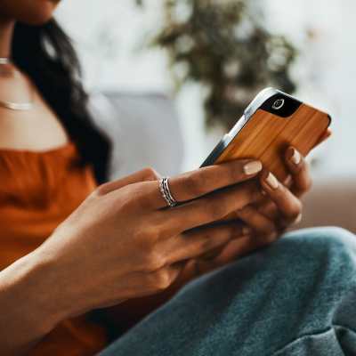 Resident using smartphone while sitting on couch at The Franklin in Ankeny, Iowa