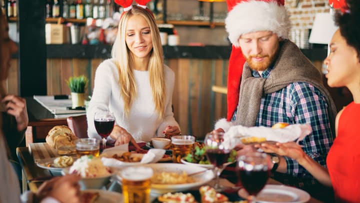 Group of people in holiday attire eating at a restaurant