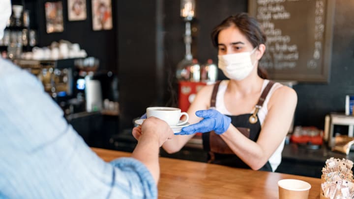 Woman handing out coffee near Olympus Midtown in Nashville, Tennessee