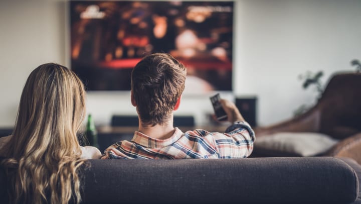 Resident couple enjoying a movie based on a book in their new home at Vistara at SanTan Village in Gilbert, Arizona