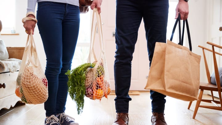 Residents couple returning home from a nearby farmers market with reusable shopping bags at The Hawthorne in Jacksonville, Florida