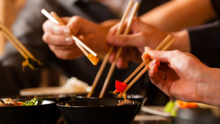 Friends enjoying food with chopsticks