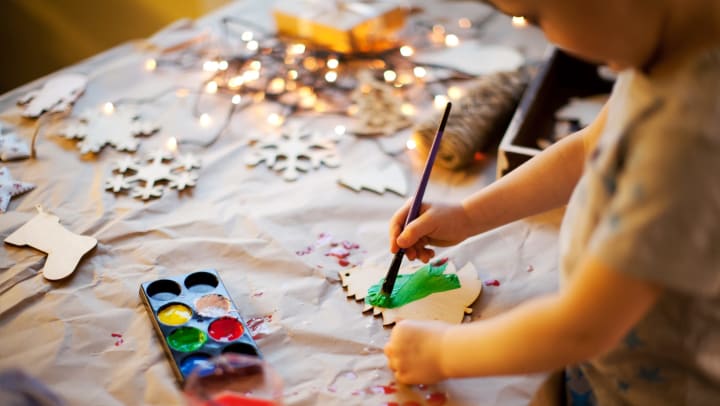 Child painting wooden ornaments