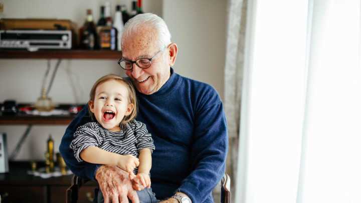 Older adult with young child seated indoors, {{location_name}} in {{location_city}}, {{location_state_name}}