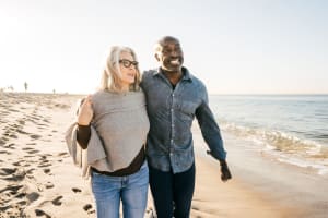 A smiling couple walking along a beach near Mariposa at Ella Boulevard in Houston, Texas