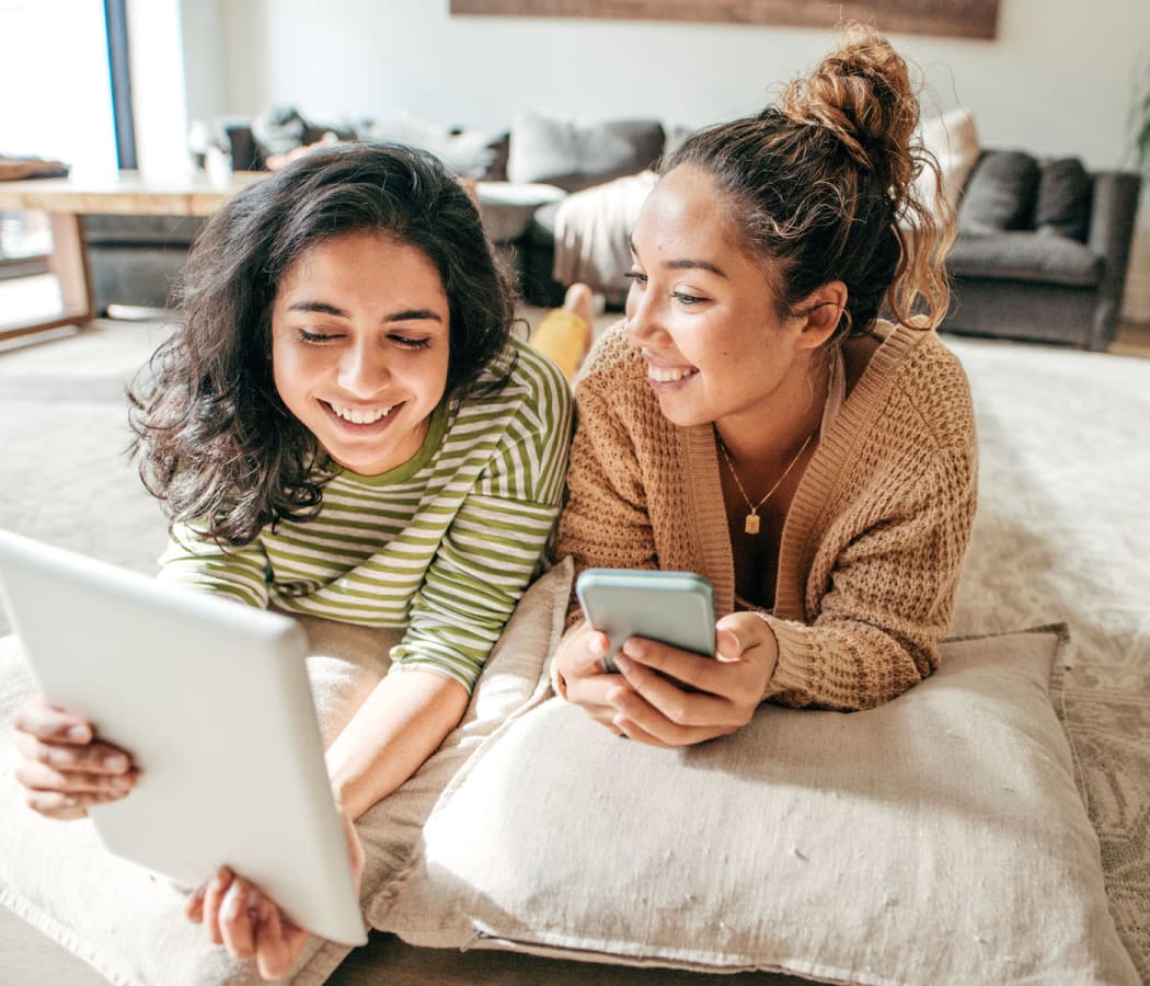 Roommates checking out our communities policies on a tablet device in their new home at The Retreat at Arden Village Apartments in Columbia, Tennessee