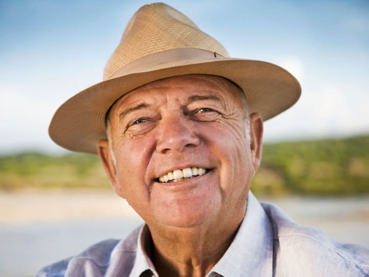 Male senior wearing a hat outside on a beautiful day. 