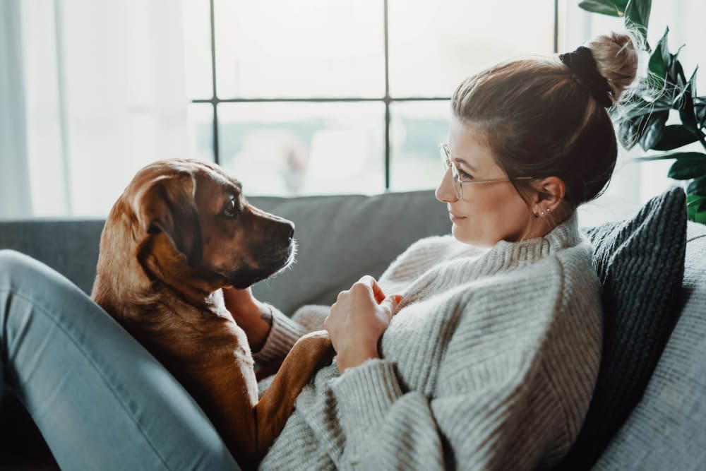 Happy resident and her dog loving their new home at Latitude at Mallard Creek in Charlotte, North Carolina