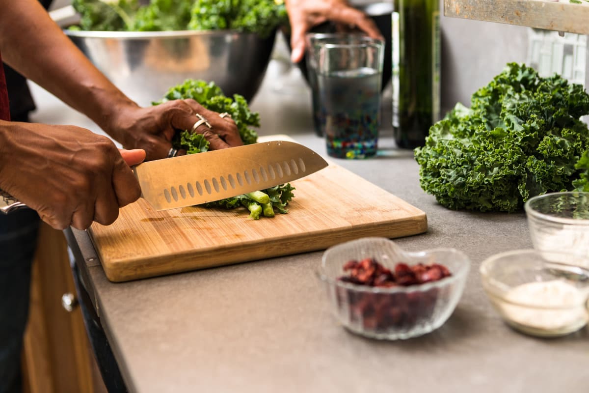 Residents cutting and preparing food in their modern kitchen at Amira Bloomington in Bloomington, Minnesota