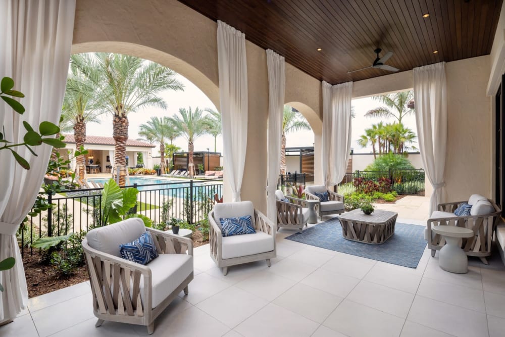 Relaxing poolside seating with palm trees and loungers at Locklyn West Palm, West Palm Beach, Florida