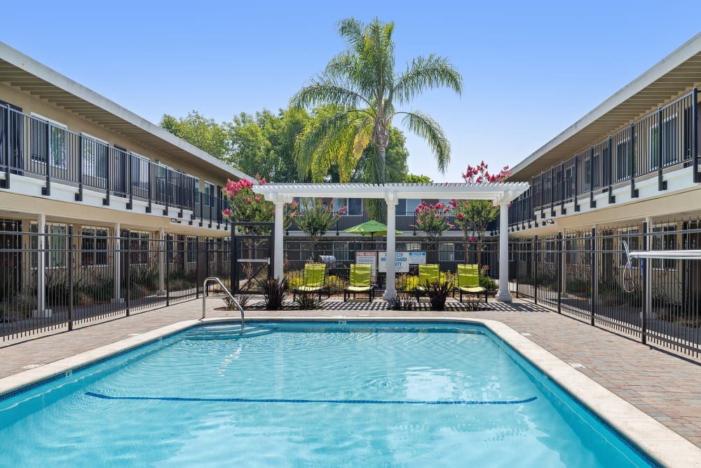 Relaxing by the pool at Coral Gardens Apartment Homes in Hayward, California