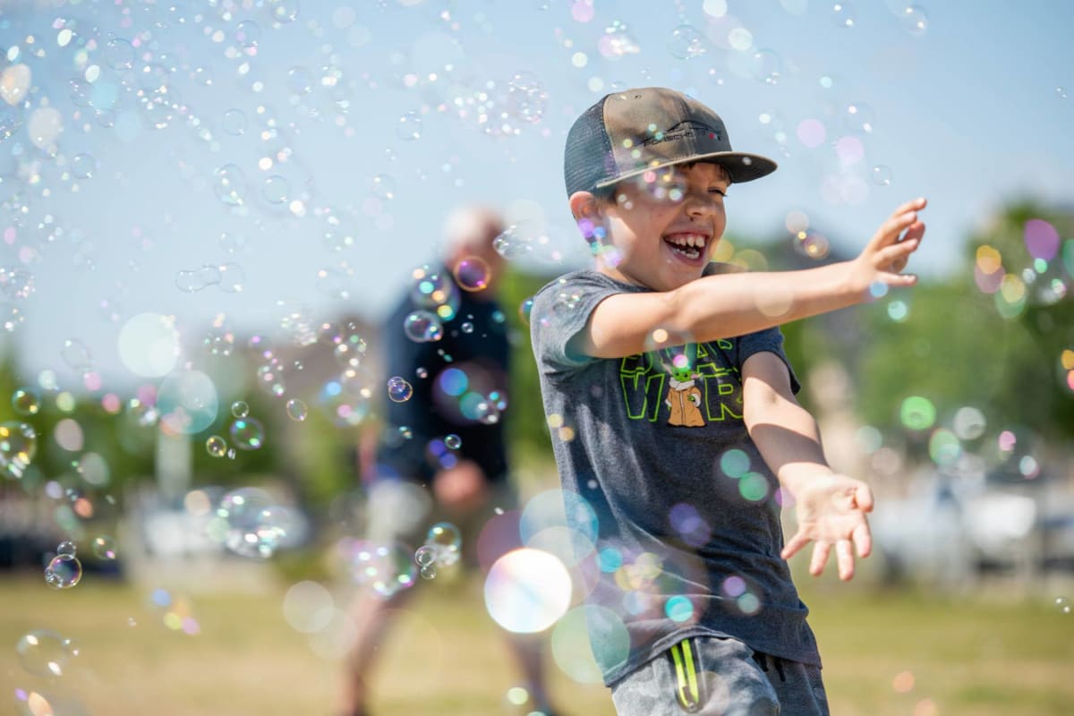 Boy playing with bubbles on beautiful day at BB Living Harvest in Argyle, Texas