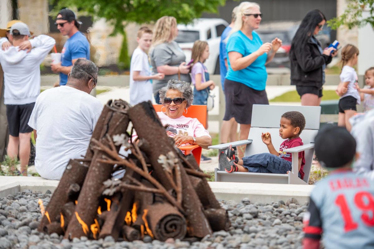 Family enjoying food by campfire at BB Living Harvest in Argyle, Texas