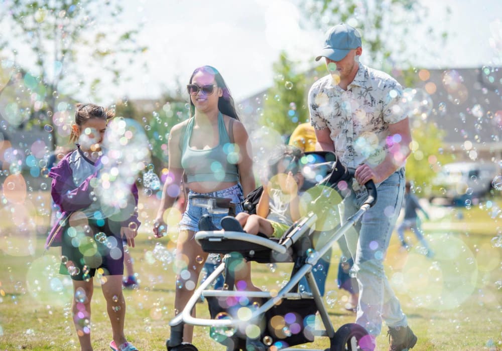 Family walking through bubbles in nice large grass area at BB Living Harvest in Argyle, Texas