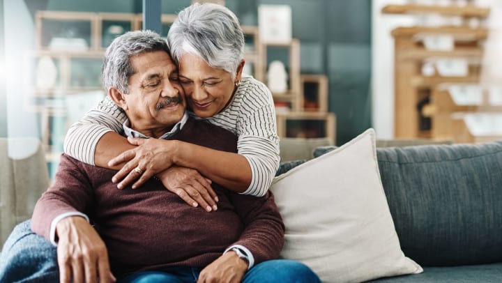 Woman smiling with her arms around her husband 